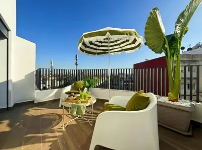 a balcony with a table and chairs and an umbrella at Maya Suites - Habous Old Town - Panoramic City View in Casablanca