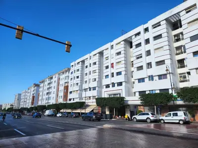 a large white building with cars parked on a street at Apartment or Rooms for couples and single people in luxurious apartment in Rabat