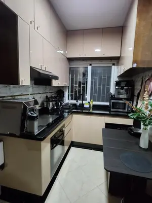 a kitchen with white cabinets and black appliances at Apartment or Rooms for couples and single people in luxurious apartment in Rabat