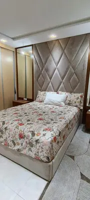 a bedroom with a large bed with a large headboard at Samir in Temara