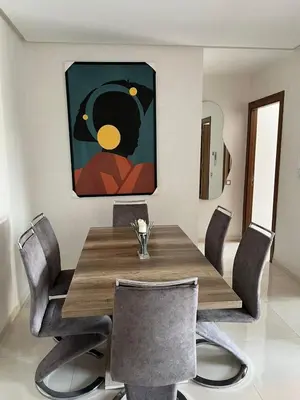 a dining room with a wooden table and chairs at Costa in Bouznika