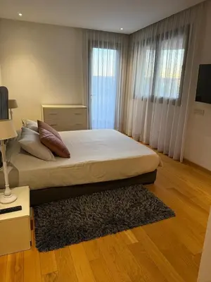 a bedroom with a large bed with white sheets and a rug at Marina de Casablanca in Casablanca
