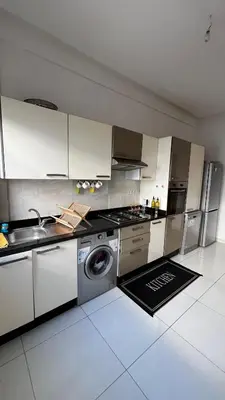 a kitchen with white cabinets and a washing machine at Magic house in Mansouria