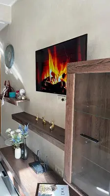 a living room with a fireplace with a tv on the wall at Magic house in Mansouria