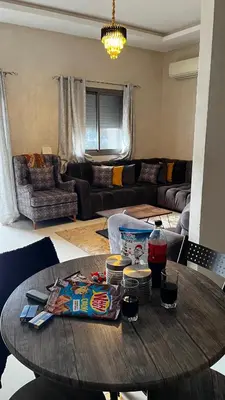 a living room with a wooden table and a couch at Magic house in Mansouria