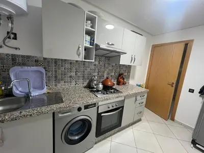 a kitchen with a stove and a washing machine at Dar Lakbira Bouznika in Bouznika