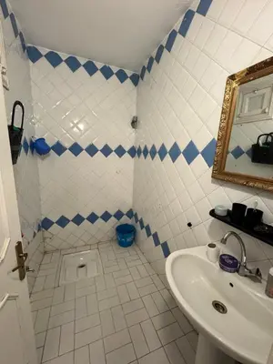 a blue and white bathroom with a sink and a mirror at Petit Apparemment pas chère à 3km du grand stade de rabat in Temara