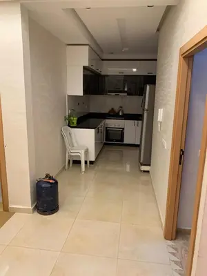 an empty kitchen with a chair and a refrigerator at Bouznika in Bouznika