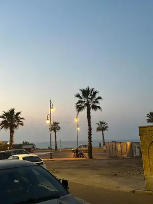 a parking lot with palm trees and a sunset at oceon vue rabat center in Rabat