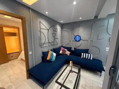 a living room with a blue couch with pillows at Le studio Chic in Casablanca