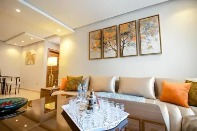 a living room with a couch and a table at Elegance - 2 bedrooms with Pool - 5 min Airport in Nouaseur