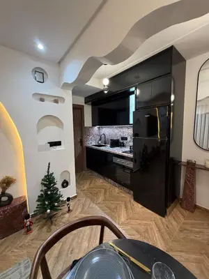 a kitchen with a black refrigerator and a christmas tree at Luxurious studio with Jacuzzi in Casablanca in Casablanca