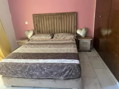 a bedroom with a large bed with a wooden headboard at Love appartement1 in Casablanca