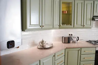 a kitchen with white cabinets and a counter top at Luxury 3 Suites - Av Annakhil - 5 Min to Stadium in Rabat