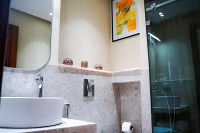 a bathroom with a shower and a sink and a mirror at Luxury 3 Suites - Av Annakhil - 5 Min to Stadium in Rabat