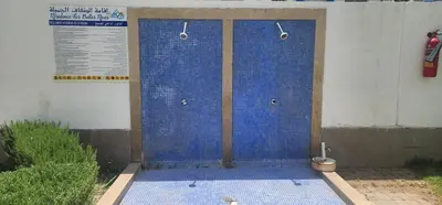 a shower with blue tiles on the side of a building at Bel appart les belles rives bouznika Couples non mariés non acceptés in Bouznika