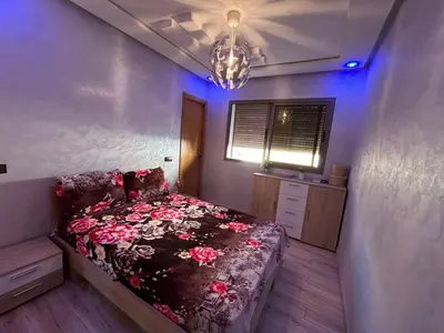 a bedroom with a bed with flowers on it at Skhirat apartment in Skhirat