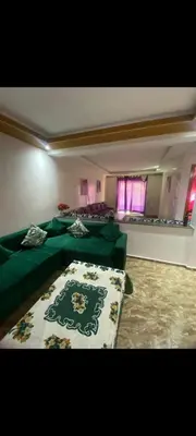 a living room with a green couch in a room at Appartement à louer in Rabat