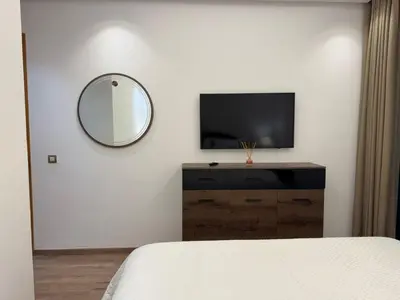 a bedroom with a mirror and a tv on a wall at Furnished and bright apartment in Rabat