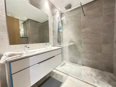 a bathroom with a sink and a shower with a mirror at Luxurious Apartment in Hay Riad in Rabat