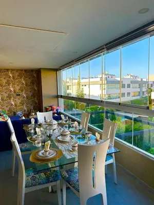 a dining room with a table and chairs and a large window at luxury furnished apartment for rent in Tamaris