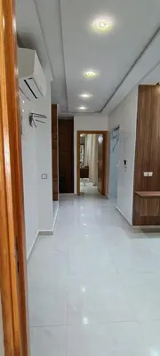 a room with a white tile floor and a hallway at Wifak temara in Temara