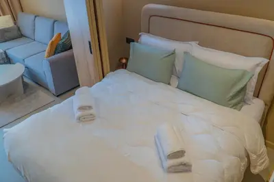 a large white bed in a room with a couch at AnfaSuites - Résidence Pashmina - Maarif - Parking in Maarif