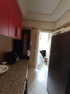 a kitchen with red cabinets and a counter top at Summer & family apartments, Cheer on your team CAN in Mohammedia