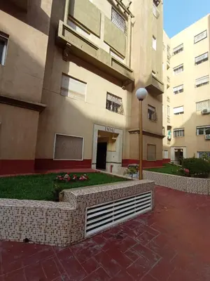 a building with a courtyard with flowers in front of it at Summer & family apartments, Cheer on your team CAN in Mohammedia