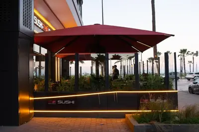 a restaurant with a red umbrella in front of a building at Luxury Studio Corniche near H2 Area in Casablanca