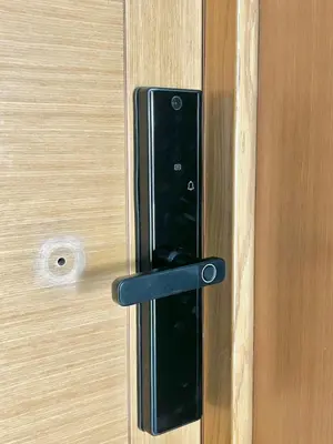 a black door handle on a wooden door at Chic 2-bedroom apartment, pool and beach 5 min away in Mohammedia