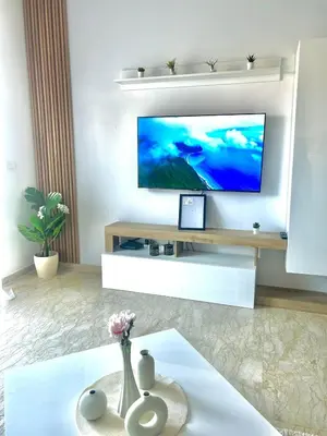 a living room with a tv and a vase with flowers at Zen Terrace Design Studio in Zenata, WiFi & Pool in Aïn Harrouda
