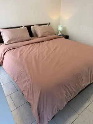 a large bed with pink sheets and pillows on it at Spacious apartment in Agdal, close to everything in Rabat