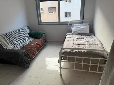 a room with a bed and a couch and a window at Spacious apartment in Agdal, close to everything in Rabat