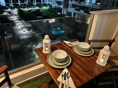 a table on a balcony with a view of a city at Studio calme Vue piscine À deux pas de la mer in Aïn Sebaa