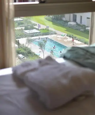a view of a swimming pool from a bedroom window at Studio calme Vue piscine À deux pas de la mer in Aïn Sebaa