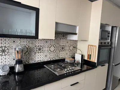 a kitchen with white cabinets and a black counter top at Opposite Train Station & Tram Modern Quiet & Meals Available in Casablanca