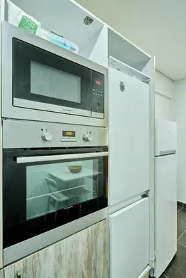 a white kitchen with a microwave and a refrigerator at Sunny Spacious 3 BR Apartment CIL view in Casablanca