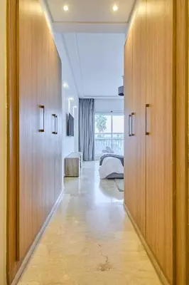 a hallway with wooden doors and a bed in a room at Sunny Spacious 3 BR Apartment CIL view in Casablanca
