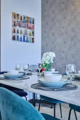 a table with blue chairs and plates on it at Sunny Spacious 3 BR Apartment CIL view in Casablanca