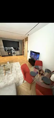 a living room with a glass table and red chairs at Apartment in Maarif in Maarif