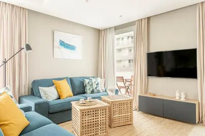 a living room with a blue couch and a flat screen tv at CFC, cozy 2 bedrooms apartment living room in Casablanca