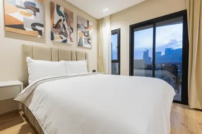 a bedroom with a white bed and a large window at Premium Studio H&M - Near CFC and Anfa Park in Casablanca