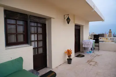 a building with a porch with a couch on a balcony at Downtown Casablanca Living Terrace & Tram Access in Casablanca