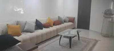 a living room with a couch with colorful pillows at Appartement près de la corniche in Casablanca