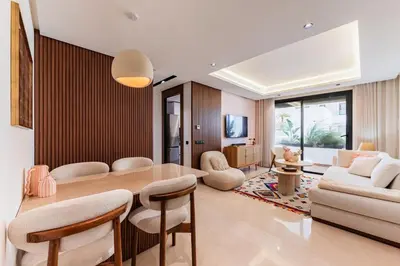 a living room with a table and chairs and a couch at Uptown Casa Anfa Luxury at Casa Finance City in Casablanca