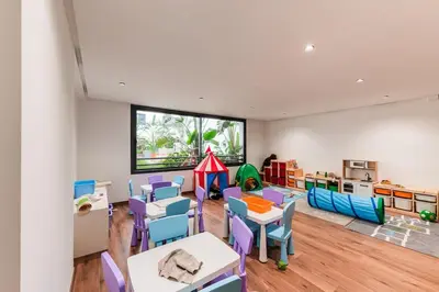 a classroom with tables and chairs and a play area at Uptown Casa Anfa Luxury at Casa Finance City in Casablanca