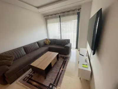 a living room with a couch and a coffee table at appartement 5min a pied du stade in Rabat