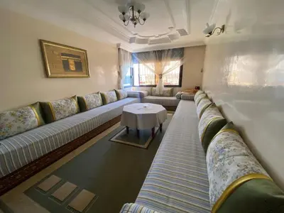 a living room with couches and a table at Palace, Appartement Rabat Agdal in Rabat