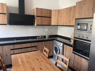 a kitchen with wooden cabinets and a table and a microwave at Beautiful beachfront villa in Dar Bouazza